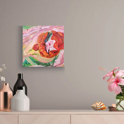 A square abstract canvas painting with vibrant pink, red, orange, and green brushstrokes, displayed on a light gray wall above a wooden console table decorated with vases and flowers.