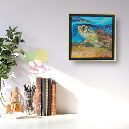 Picture of a white desk with books, pencils and branches as decor.  A square painting of a sea turtle with a blue abstract background is displayed inside a black and gold floating frame.